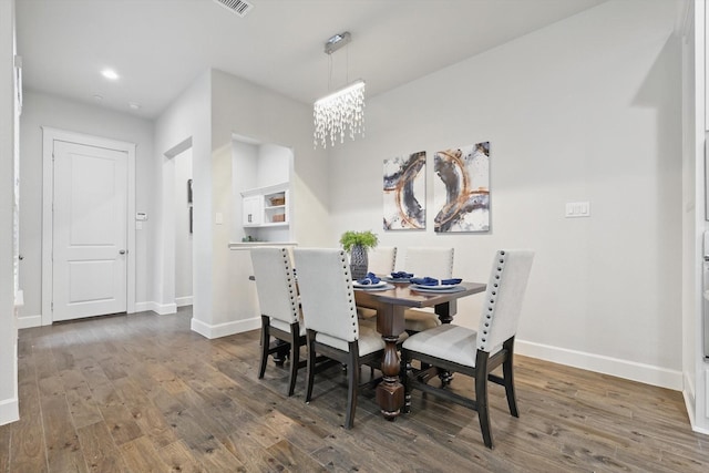 dining area featuring an inviting chandelier, wood finished floors, baseboards, and visible vents