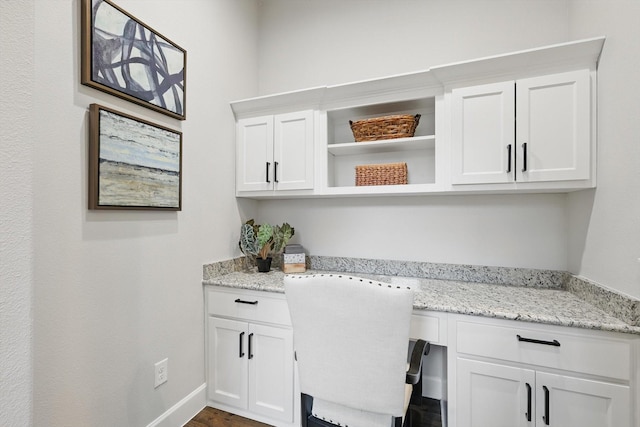 home office featuring baseboards and built in desk