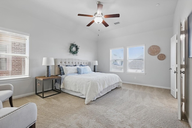 bedroom with visible vents, baseboards, light colored carpet, and ceiling fan