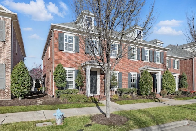 colonial inspired home with brick siding