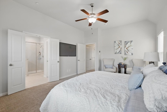 bedroom featuring a ceiling fan, ensuite bath, carpet flooring, baseboards, and vaulted ceiling