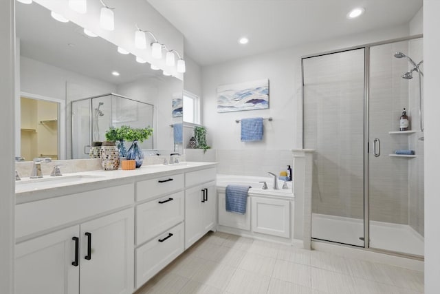 full bath with a sink, double vanity, a bath, and a shower stall