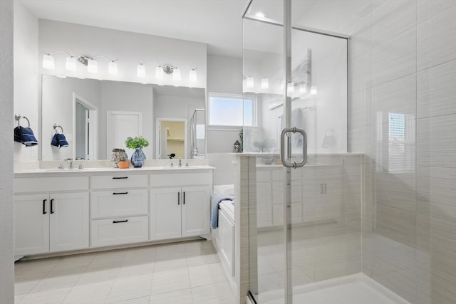 bathroom featuring tile patterned flooring, a shower stall, double vanity, and a sink