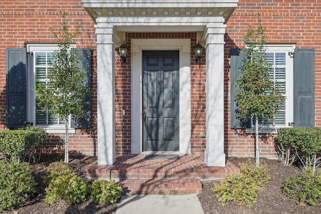 view of exterior entry with brick siding