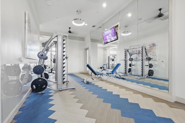 exercise room with visible vents, carpet floors, baseboards, and crown molding