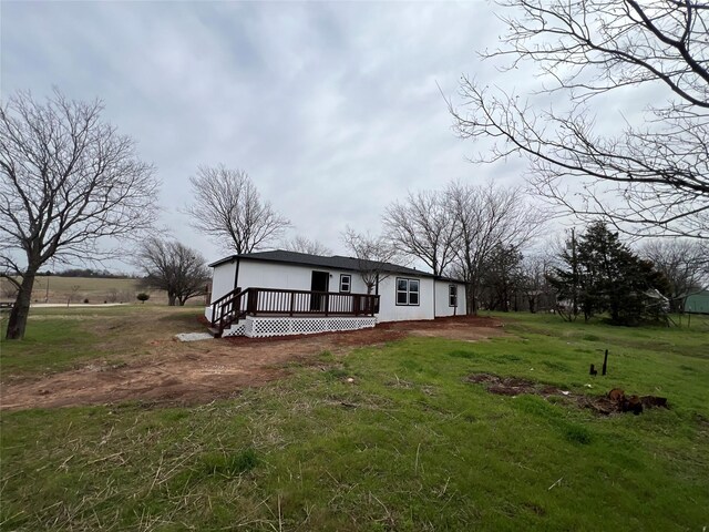 view of front of property with a deck and a front lawn