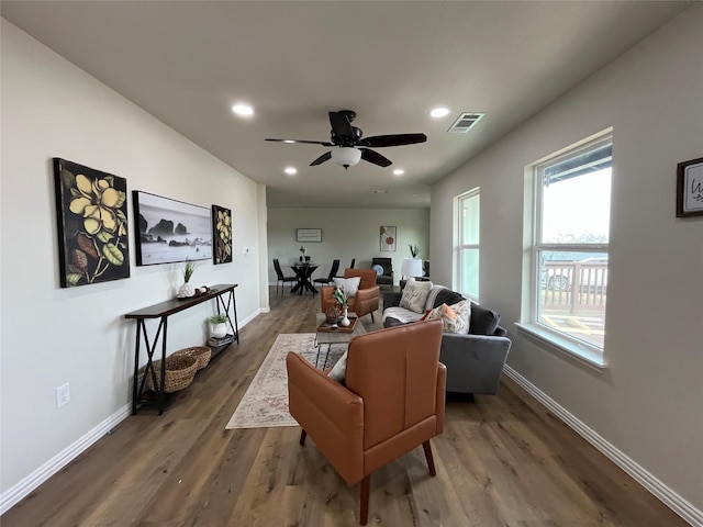 living area with visible vents, baseboards, and wood finished floors