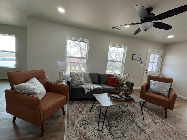 living area with recessed lighting, visible vents, baseboards, and wood finished floors