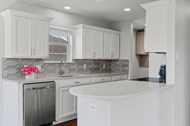 kitchen with stainless steel dishwasher, white cabinets, range, and a sink