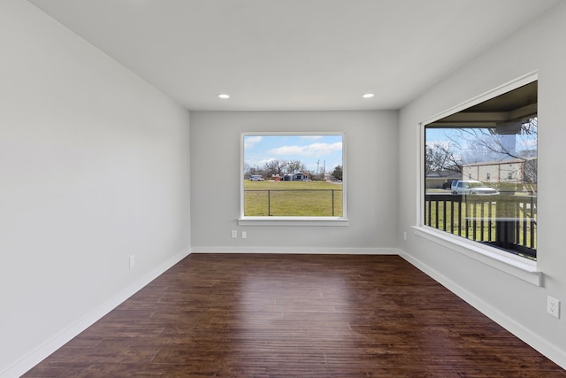 unfurnished room with recessed lighting, wood finished floors, and baseboards