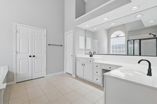 full bathroom with vanity, baseboards, a shower stall, a towering ceiling, and tile patterned floors