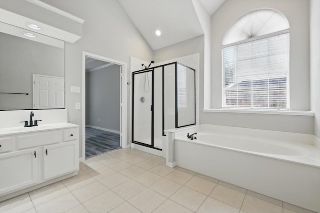 full bathroom featuring a garden tub, a shower stall, tile patterned flooring, lofted ceiling, and vanity