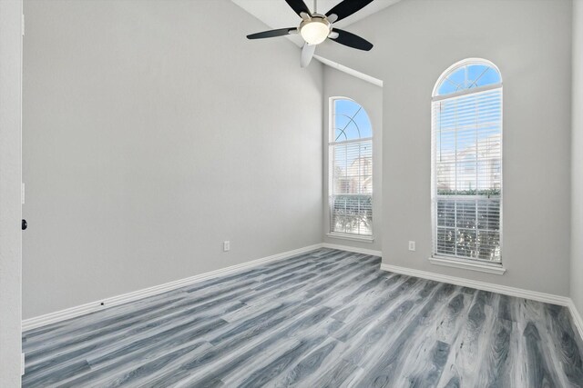 unfurnished room with wood finished floors, baseboards, and ceiling fan