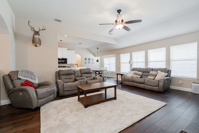 living area with visible vents, lofted ceiling, ceiling fan, and dark wood-style flooring