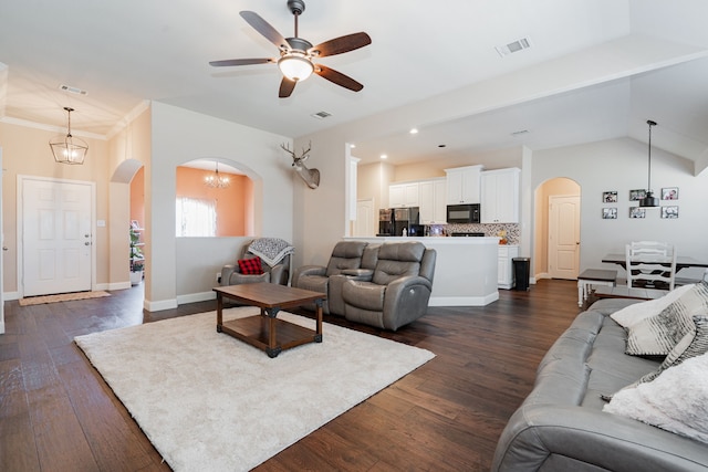 living room featuring dark wood finished floors, arched walkways, and visible vents