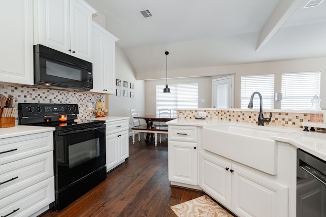 kitchen with visible vents, dark wood finished floors, vaulted ceiling, black appliances, and a sink