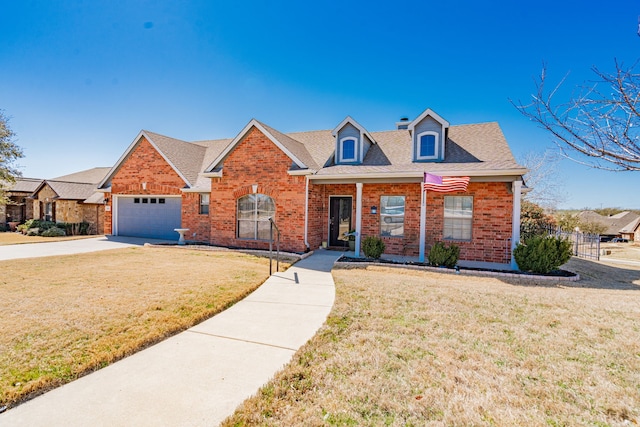 view of front of house featuring brick siding, fence, a front yard, driveway, and an attached garage