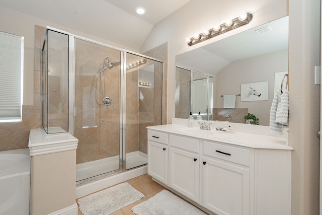 bathroom featuring vanity, a shower stall, vaulted ceiling, a garden tub, and tile patterned floors