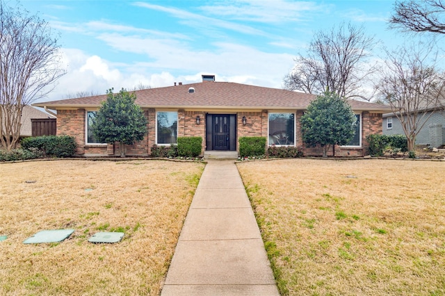 single story home with brick siding, a shingled roof, and a front lawn