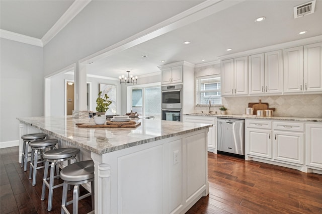 kitchen with ornamental molding, backsplash, dark wood-style floors, white cabinetry, and stainless steel appliances