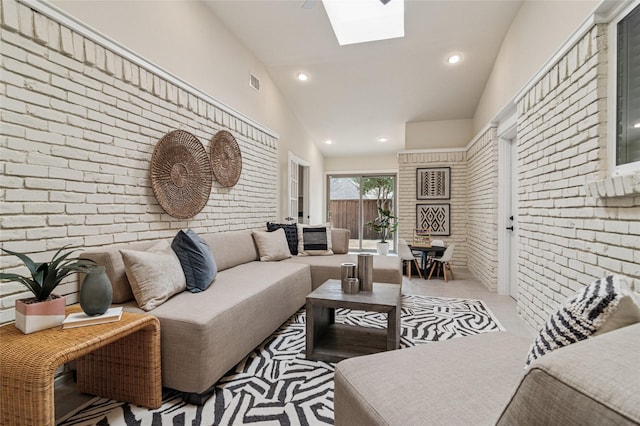 tiled living room featuring visible vents, high vaulted ceiling, recessed lighting, a skylight, and brick wall