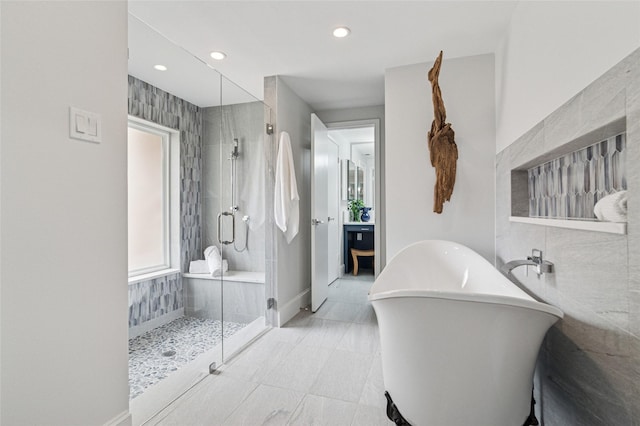 full bathroom featuring a shower stall, baseboards, recessed lighting, a freestanding tub, and tile walls