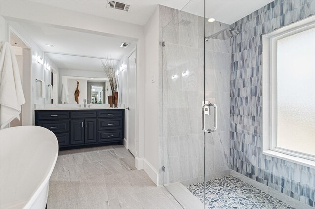 bathroom with visible vents, a stall shower, and vanity