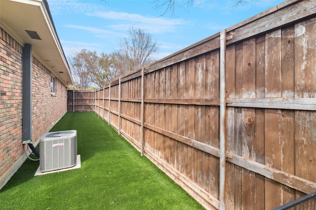 view of yard featuring a fenced backyard and central AC