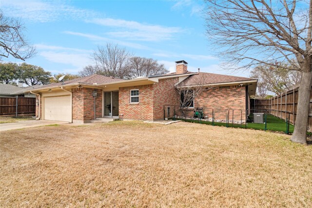 back of property with brick siding, a chimney, driveway, a yard, and an attached garage