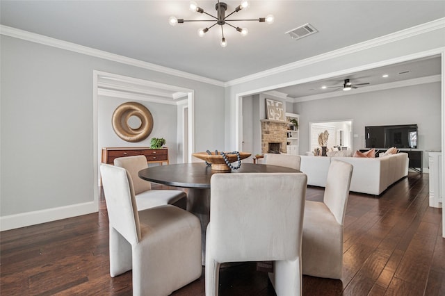 dining space with visible vents, ornamental molding, dark wood finished floors, a fireplace, and baseboards