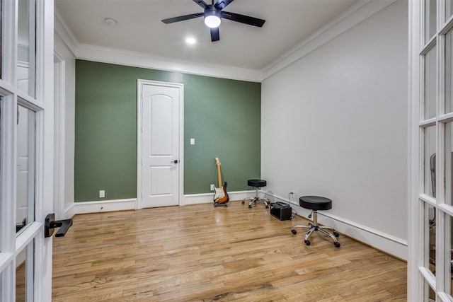 interior space featuring ceiling fan, baseboards, wood finished floors, and crown molding