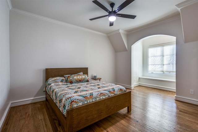 bedroom with wood finished floors, baseboards, and ornamental molding