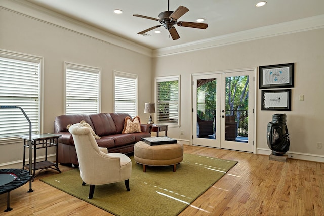 living room featuring french doors, crown molding, baseboards, and wood finished floors