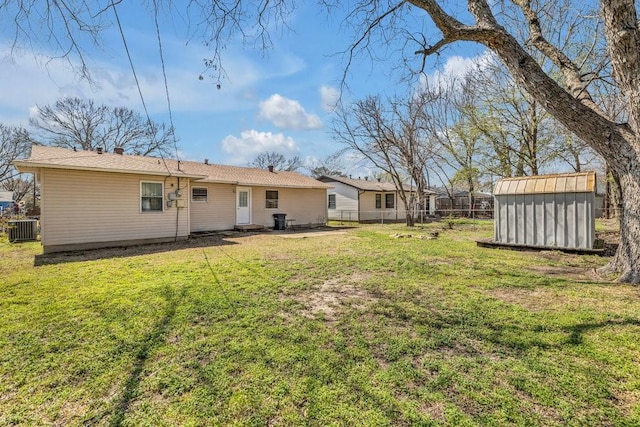 exterior space featuring an outbuilding, a storage shed, central AC, and fence