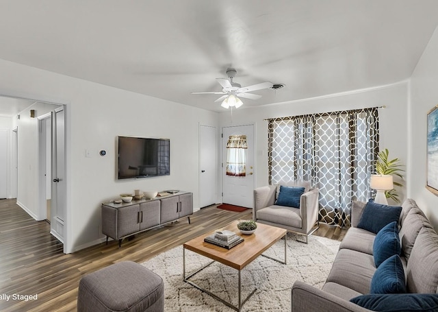 living area featuring a ceiling fan, wood finished floors, and baseboards