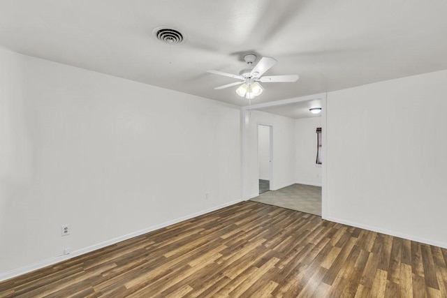 spare room featuring a ceiling fan, wood finished floors, visible vents, and baseboards