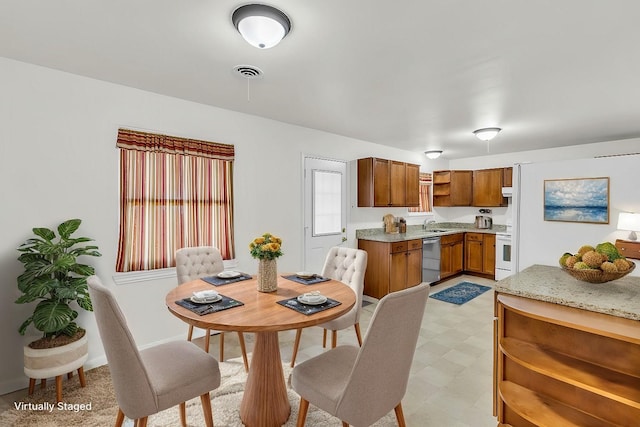 dining space featuring visible vents, light floors, and baseboards