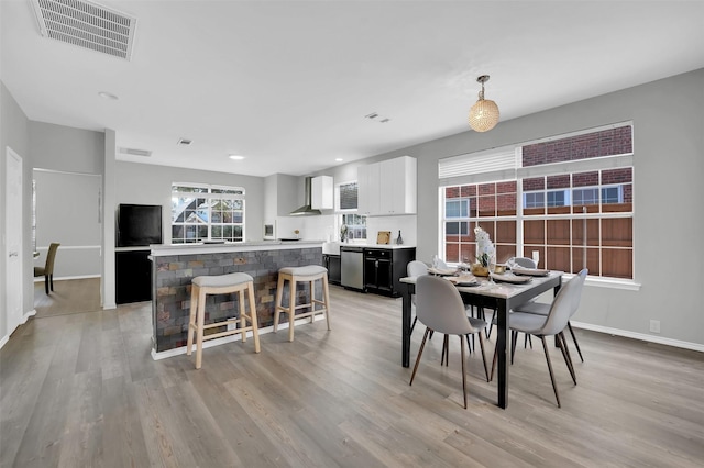 dining area with visible vents, baseboards, and light wood-style floors