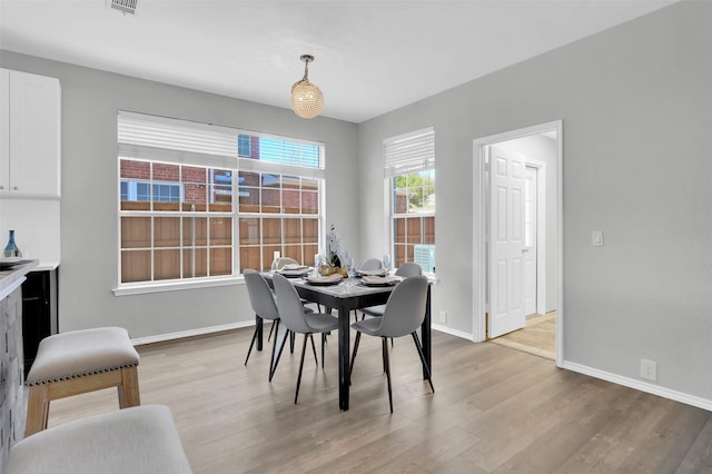 dining space featuring visible vents, baseboards, and light wood-type flooring