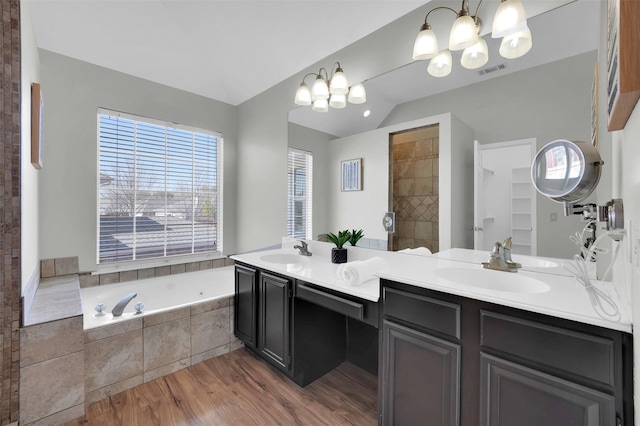 full bath featuring a sink, visible vents, lofted ceiling, and a bath