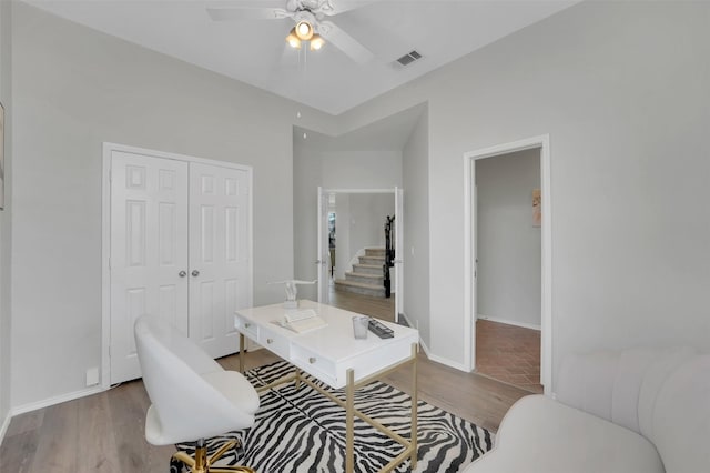 home office featuring baseboards, wood finished floors, visible vents, and ceiling fan