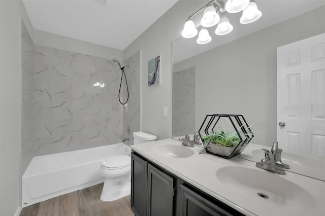 bathroom featuring double vanity, toilet, wood finished floors, and a sink