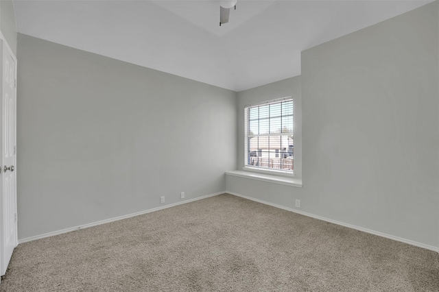 carpeted spare room featuring baseboards and ceiling fan