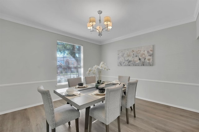 dining room with an inviting chandelier, wood finished floors, and crown molding