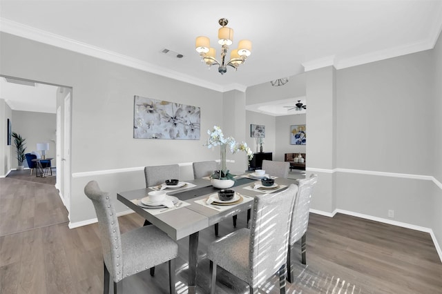 dining room featuring visible vents, crown molding, baseboards, and wood finished floors