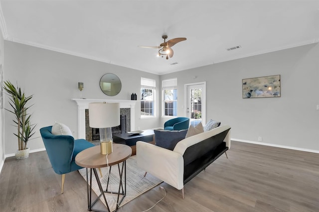 living room featuring visible vents, a ceiling fan, wood finished floors, a fireplace, and baseboards