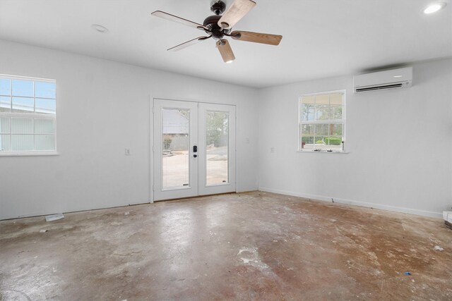 empty room featuring a wall mounted air conditioner, a ceiling fan, french doors, baseboards, and unfinished concrete floors