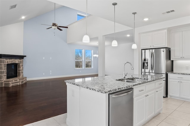 kitchen with visible vents, stainless steel appliances, open floor plan, and a sink