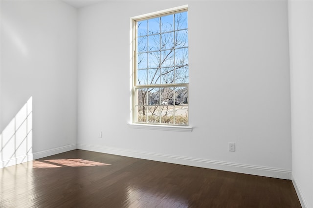 empty room featuring dark wood finished floors and baseboards