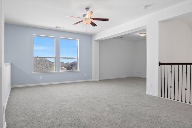 spare room with baseboards, carpet, visible vents, and ceiling fan